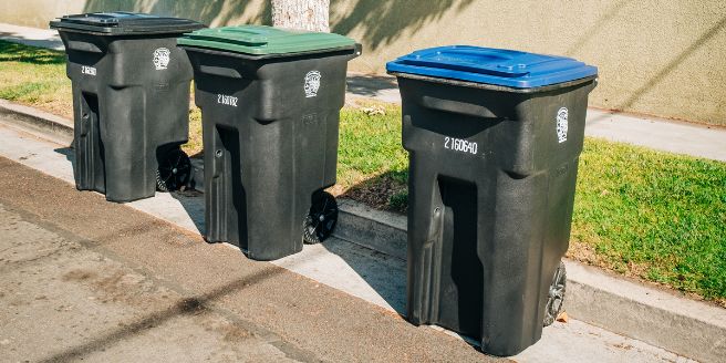 Three City of Burbank bins sitting curbside; recycling, organics and trash.