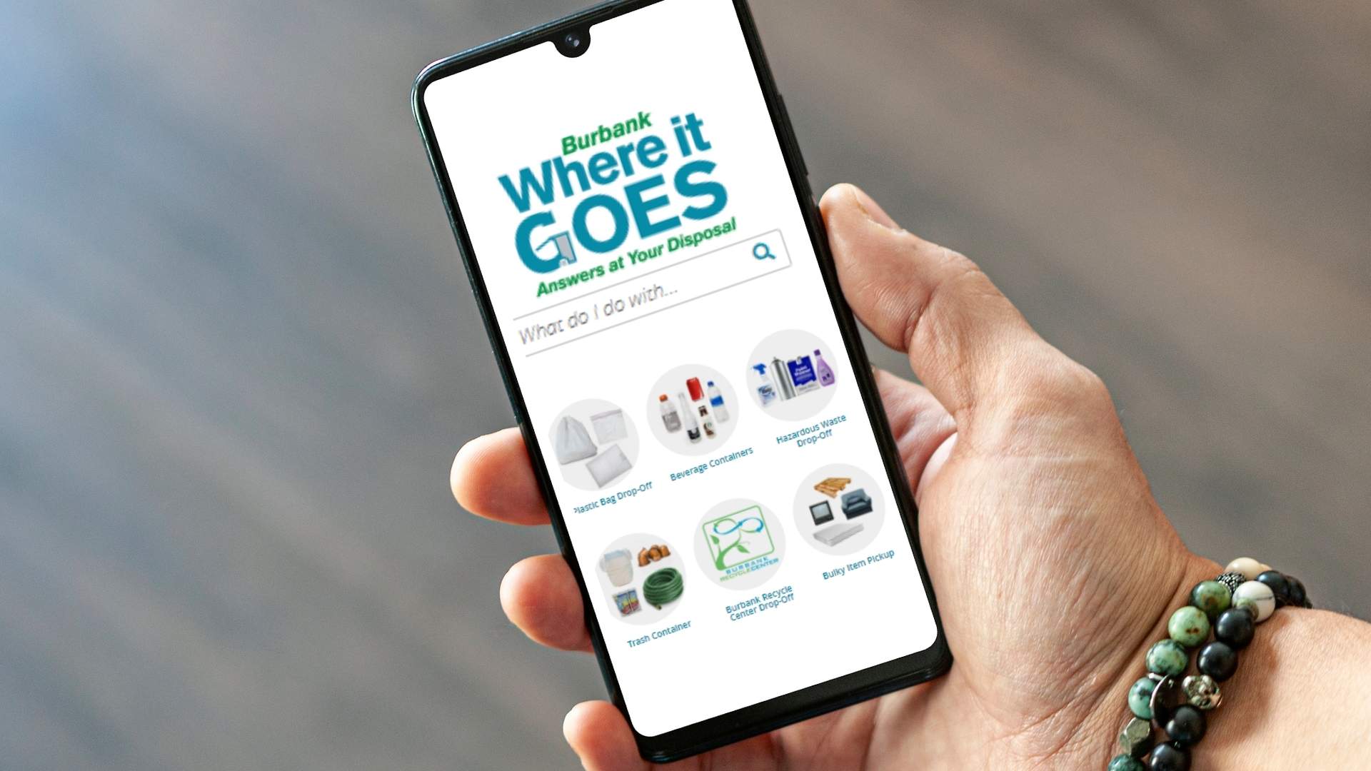 A hand holding up a smartphone. The smart phone depicts the City of Burbank's website, "Where it Goes"