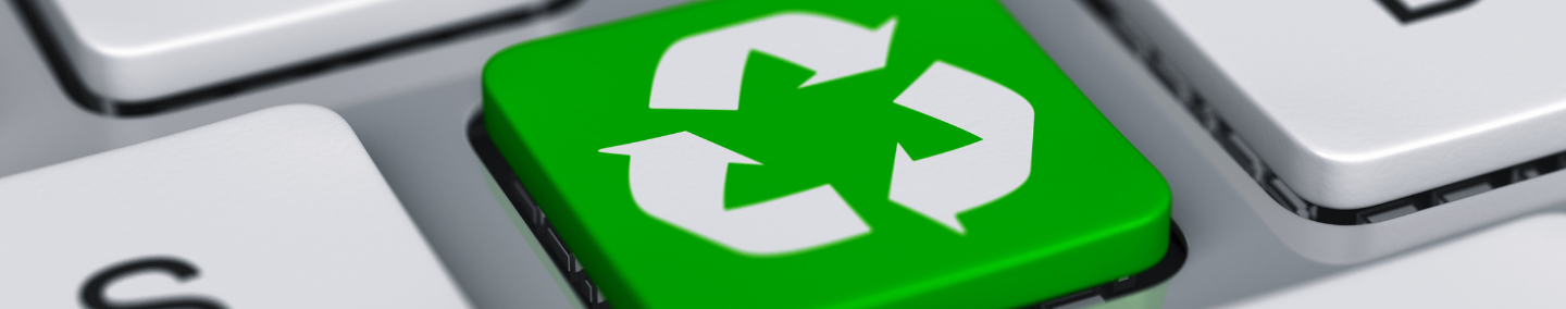 A macro image of a laptop keyboard key that is green with a white recycle logo.