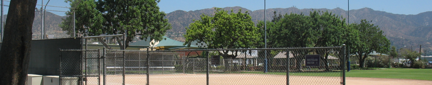 A photo of Johnny Carson Park playground, shade structure, and children playing.