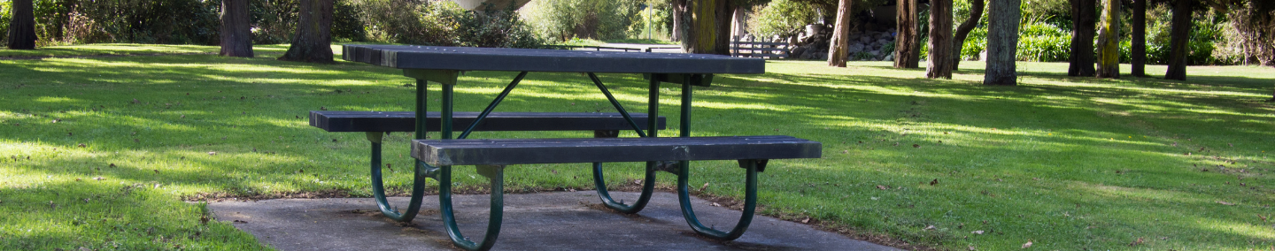 A photo of Johnny Carson Park playground, shade structure, and children playing.