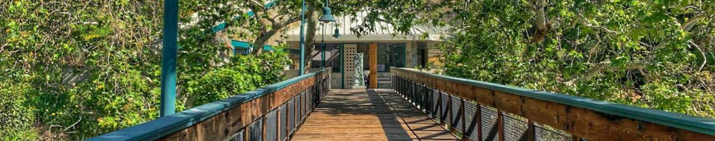 A photo of Johnny Carson Park playground, shade structure, and children playing.