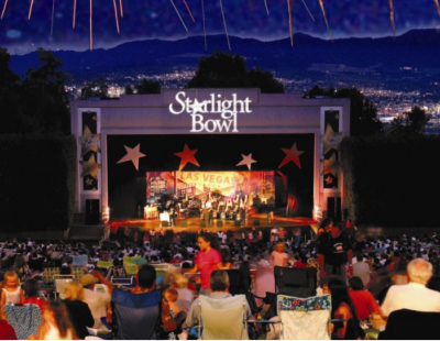 A crowd is watching a concert at the outdoor amphitheater.