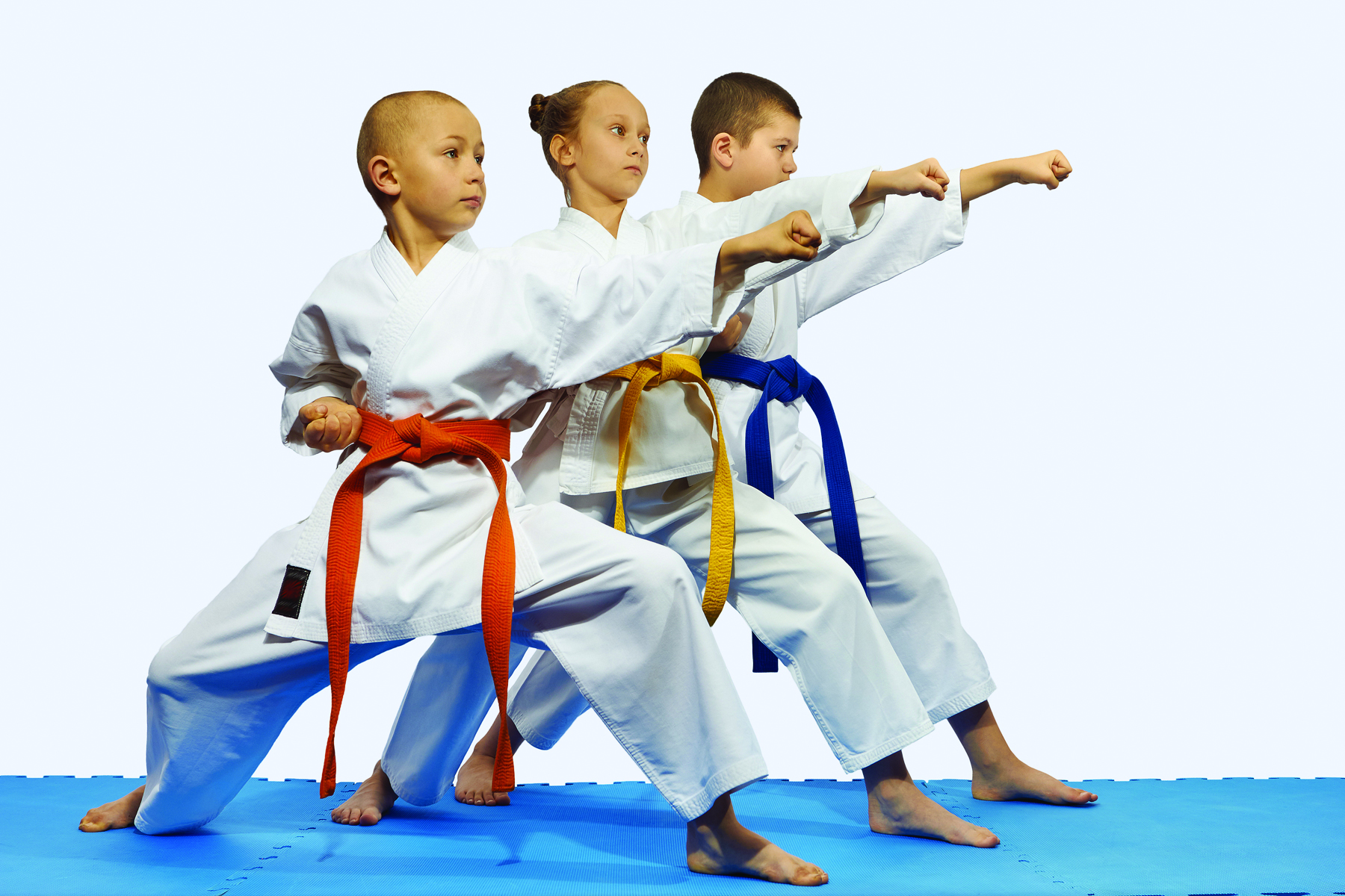 Three youth are practicing martial arts.