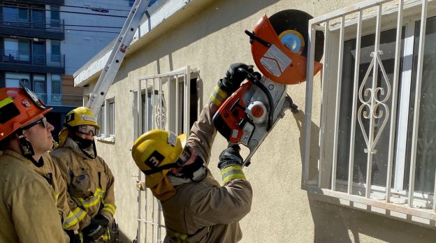 firefighter about to saw into the side of a house