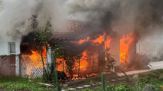 daytime scene of a house on fire