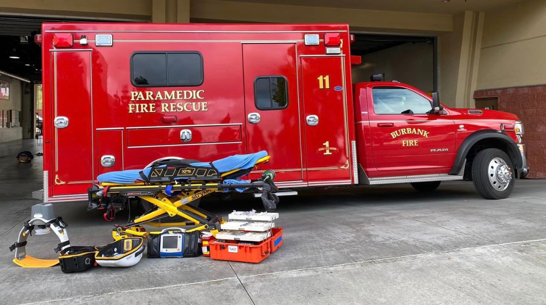 EMS vehicle and gurney with medical equipment nearby