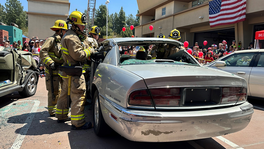 Live demonstration of firefighters extricating someone from a car for Fire and Police Service Day