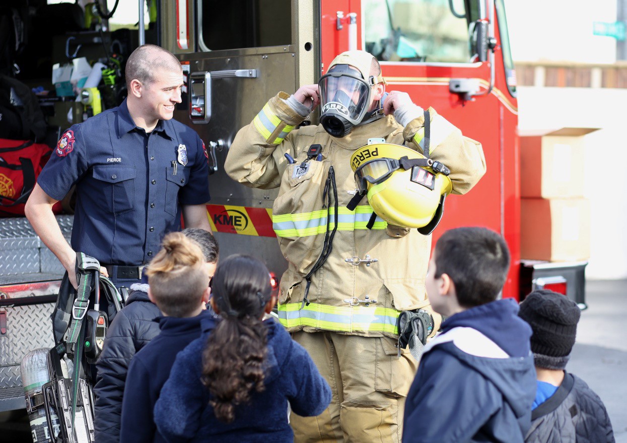 Fireman giving a demonstration of his gear to a group of children