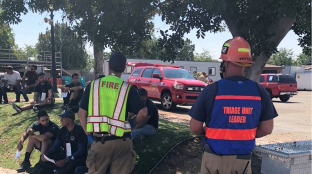 members of fire department watching EMS members work