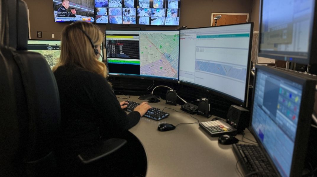 Support services at work in front of several computer monitors
